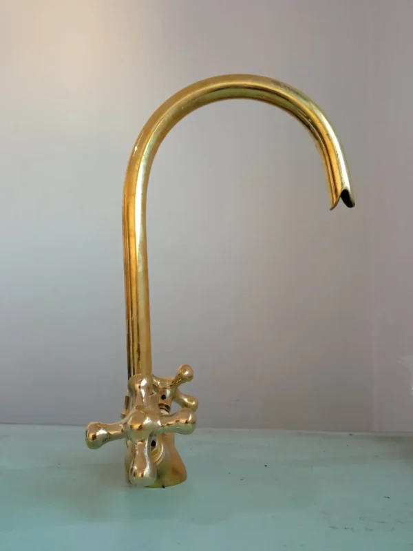 Premium brass kitchen faucet with high-arched spout and dual-handle design, perfect for modern and traditional kitchens.