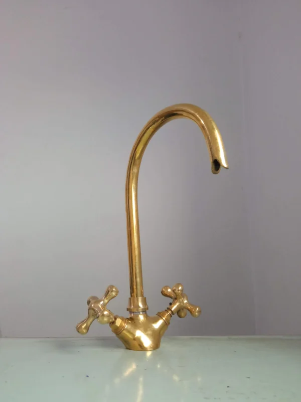 Premium brass kitchen faucet with high-arched spout and dual-handle design, perfect for modern and traditional kitchens.